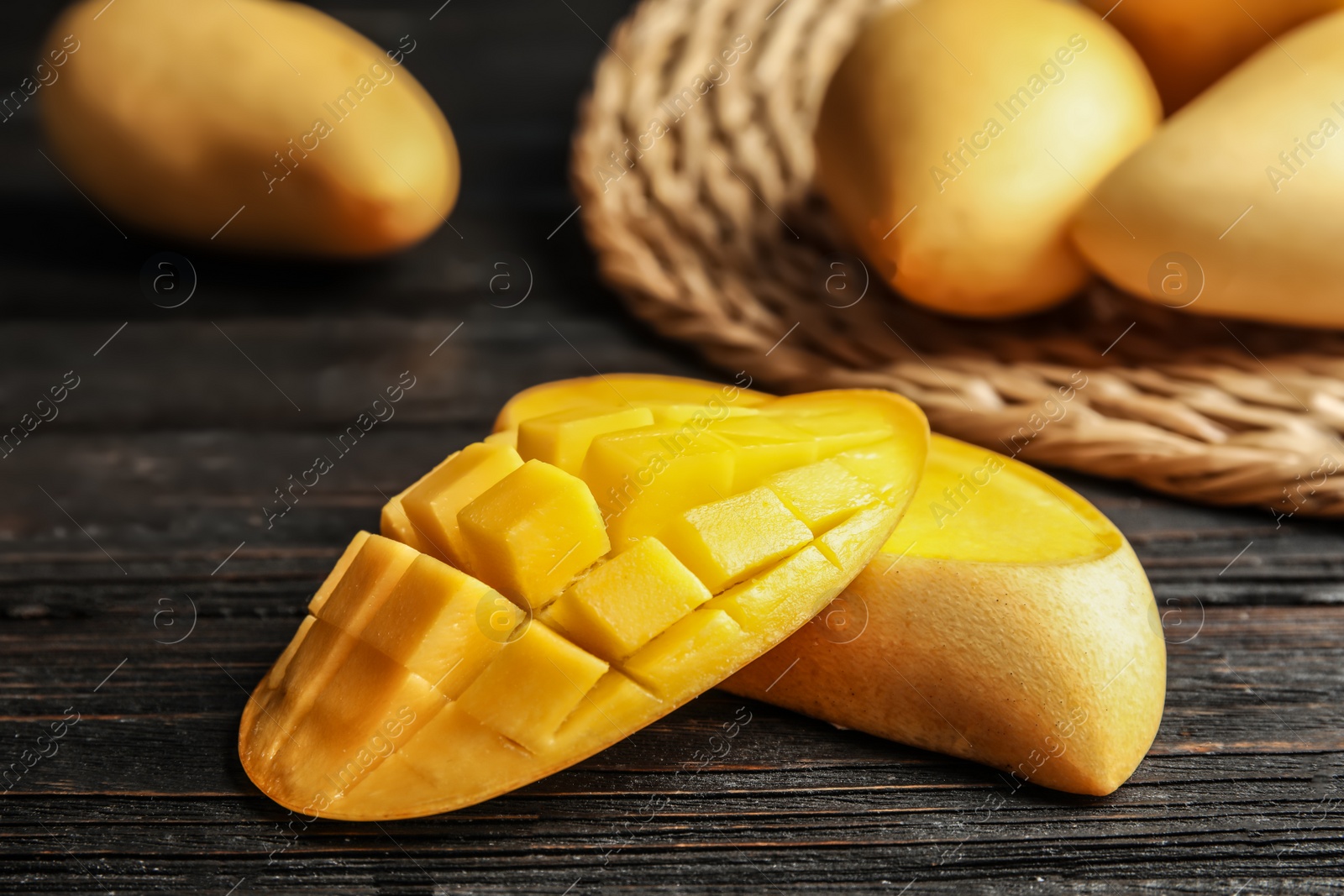 Photo of Ripe cut mango on wooden table, closeup