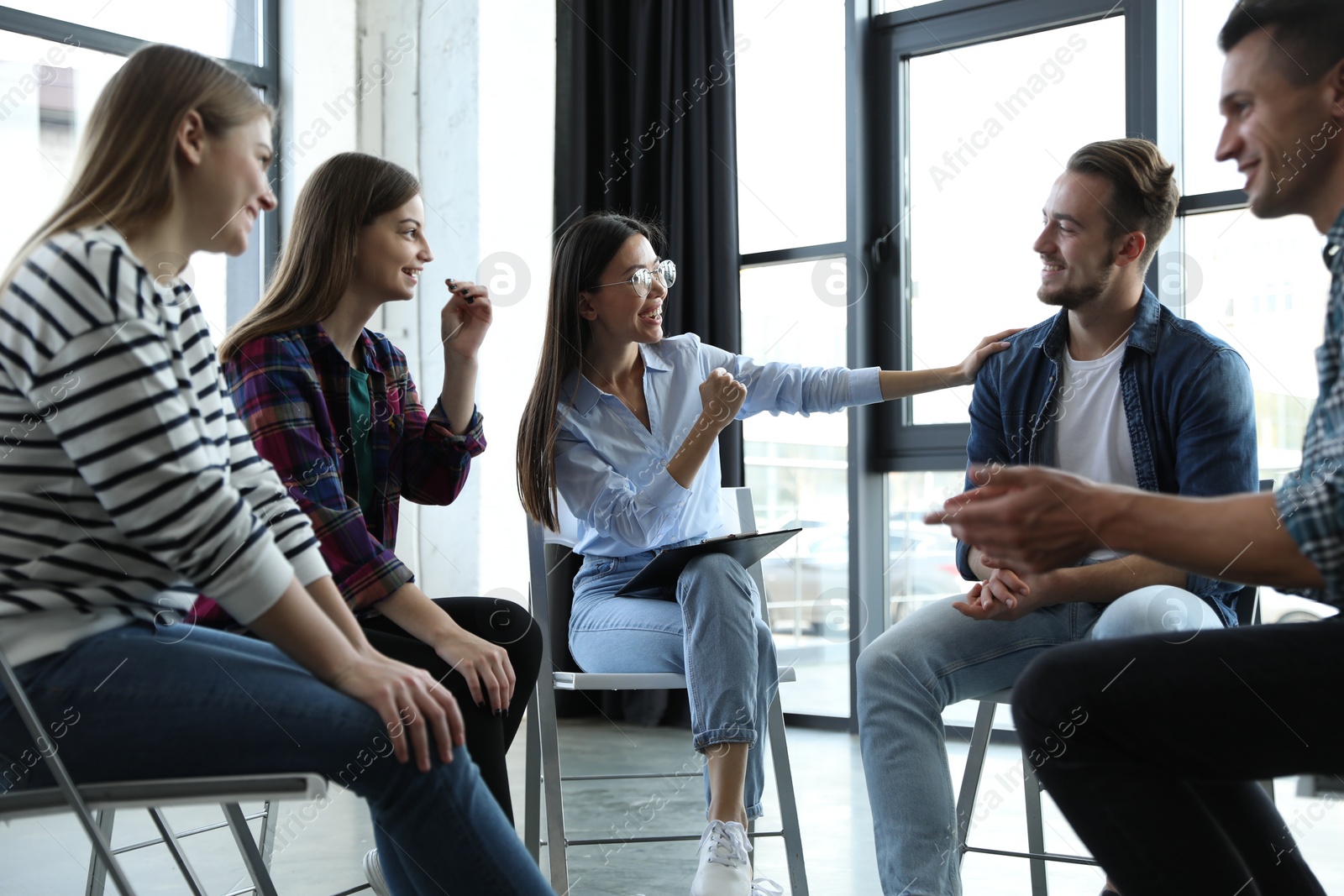 Photo of Psychotherapist working with patients in group therapy session indoors