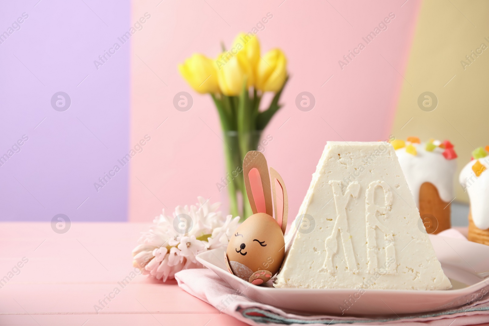 Photo of Traditional cottage cheese Easter paskha and egg with bunny ears on pink wooden table, space for text