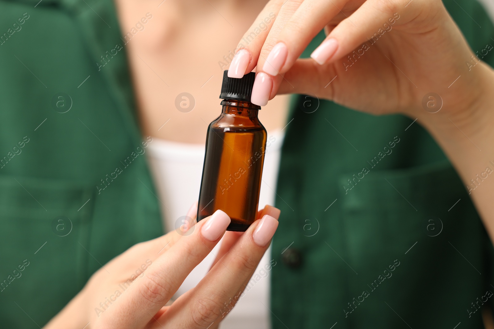 Photo of Aromatherapy. Woman with bottle of essential oil, closeup