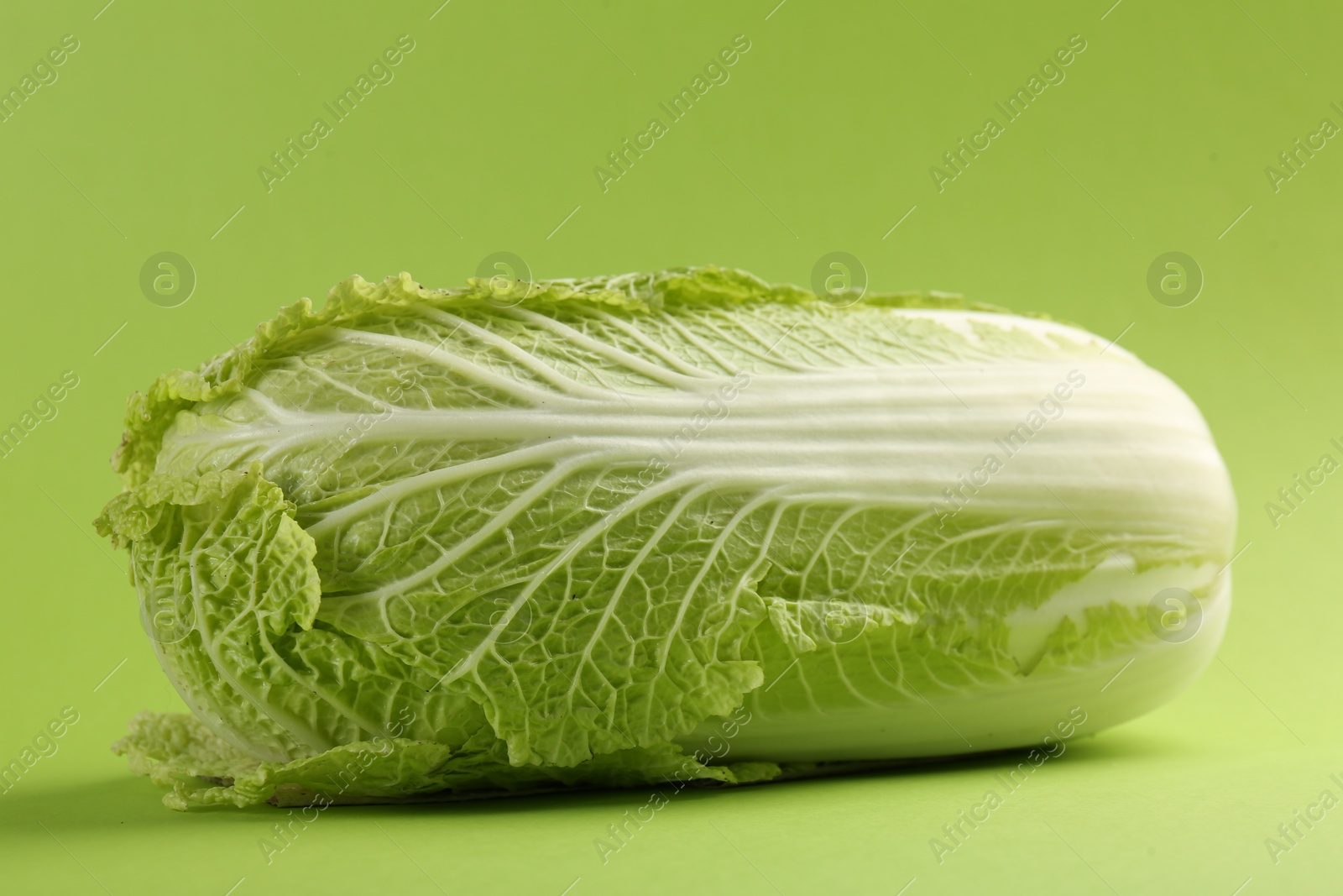 Photo of Fresh ripe Chinese cabbage on light green background, closeup