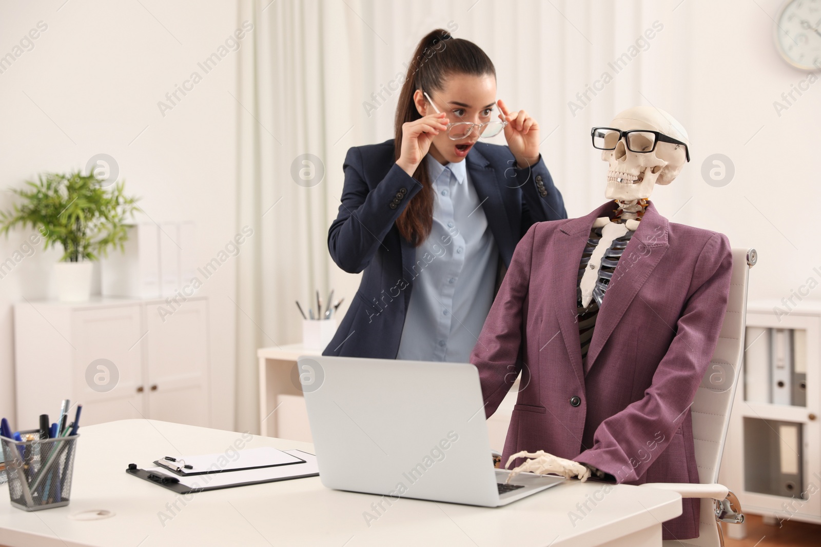 Photo of Young woman working with skeleton in office