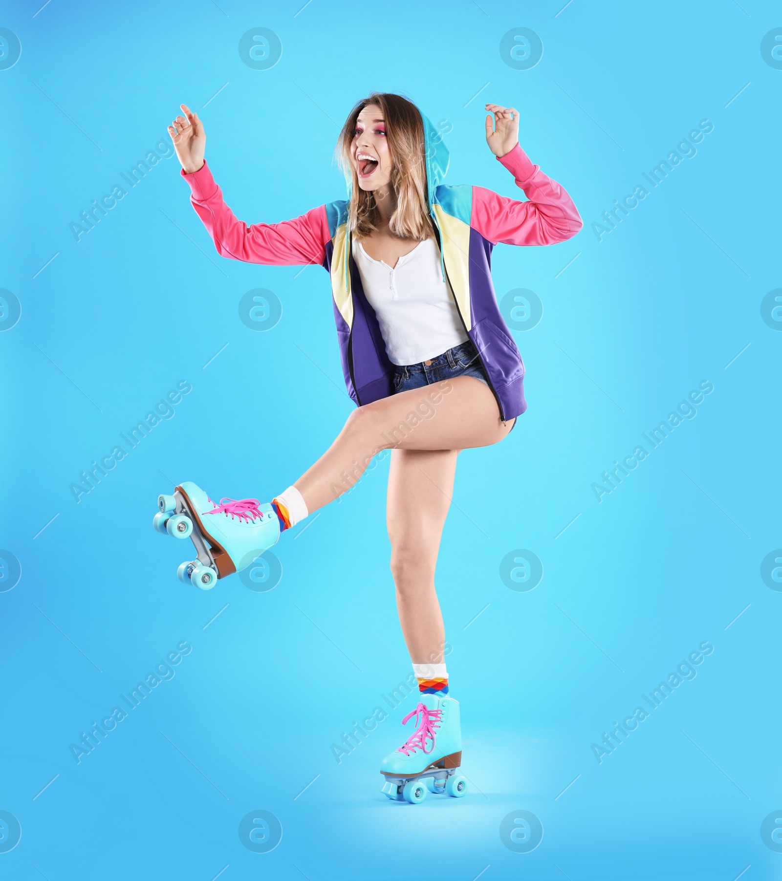 Photo of Young woman with retro roller skates on color background