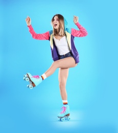 Young woman with retro roller skates on color background