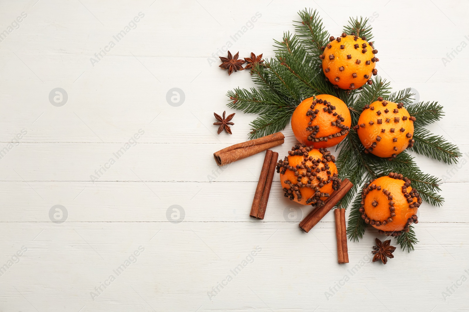 Photo of Flat lay composition with pomander balls made of fresh tangerines on white wooden table. Space for text