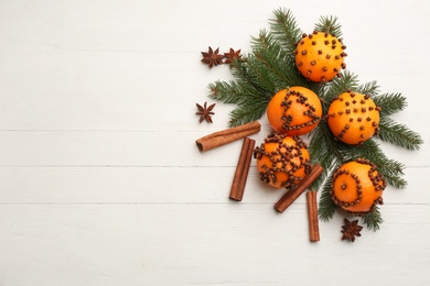 Flat lay composition with pomander balls made of fresh tangerines on white wooden table. Space for text