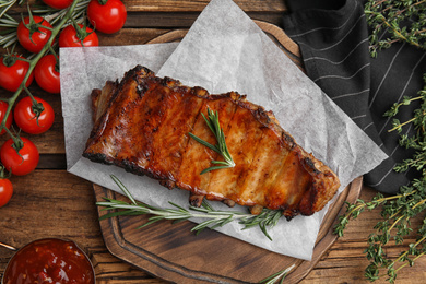 Photo of Tasty grilled ribs on wooden table, flat lay