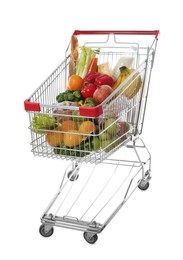 Photo of Shopping cart with fresh groceries on white background