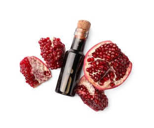 Photo of Bottle of pomegranate sauce and fresh ripe fruit on white background, top view