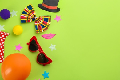 Photo of Flat lay composition with clown's accessories on green background. Space for text