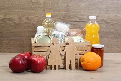 Photo of Humanitarian aid for elderly people. Different donation food and figures of senior couple on wooden table