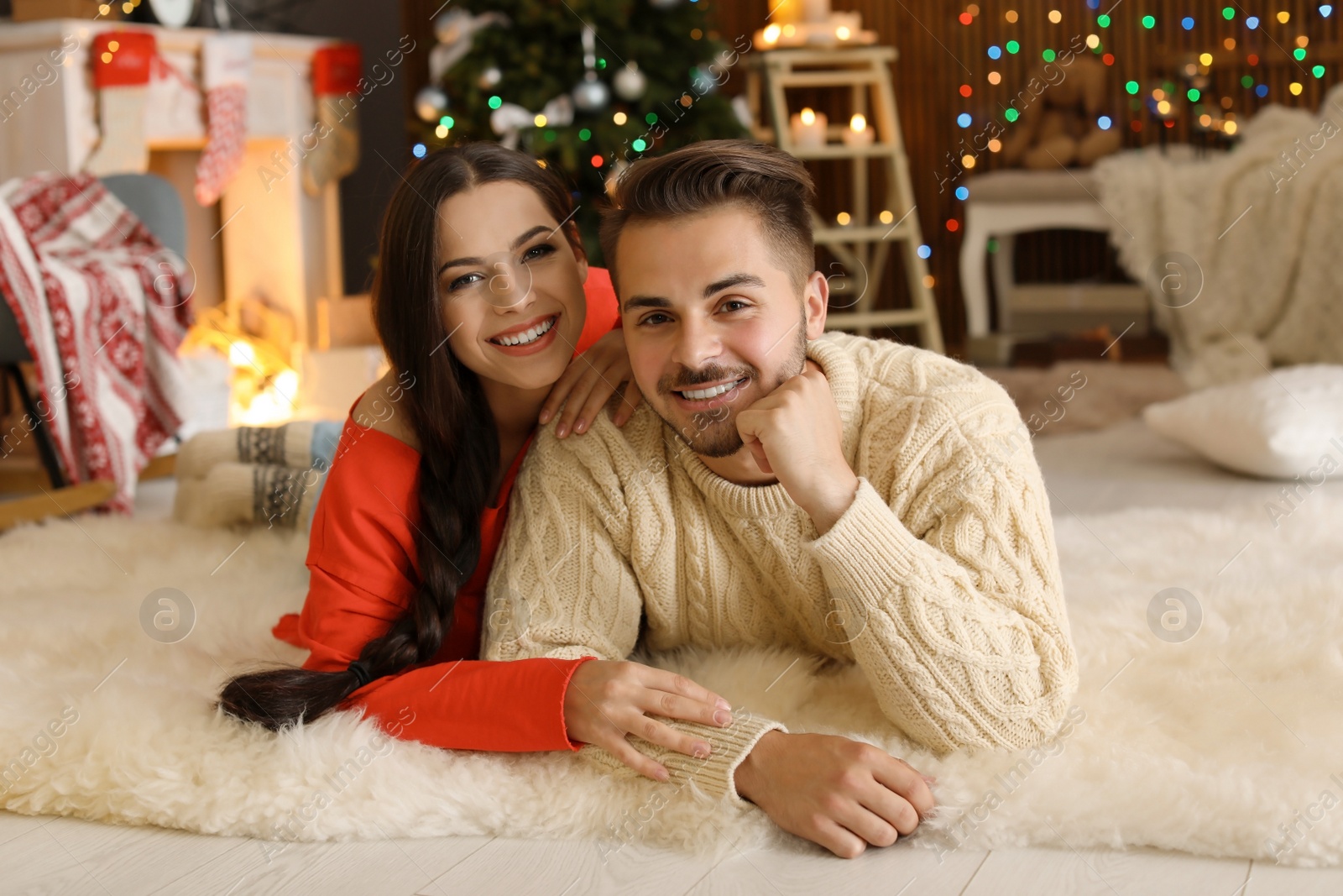 Photo of Happy young couple lying on floor at home. Christmas celebration