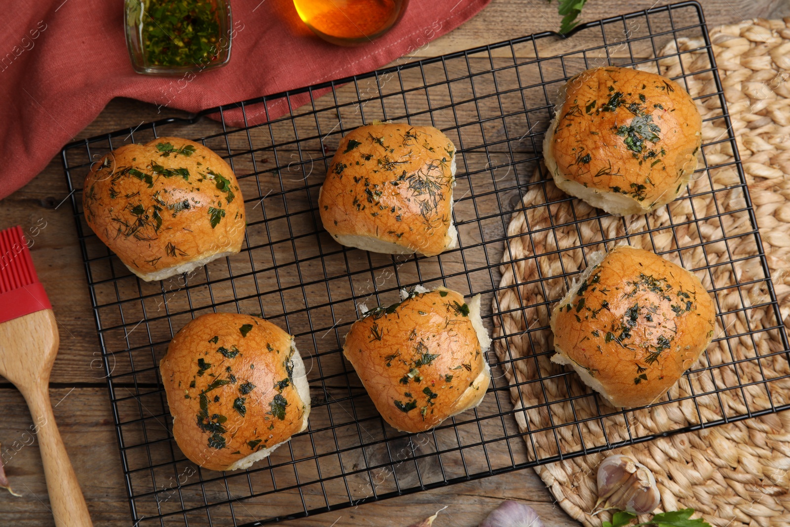 Photo of Traditional Ukrainian bread (Pampushky) with garlic on wooden table, flat lay