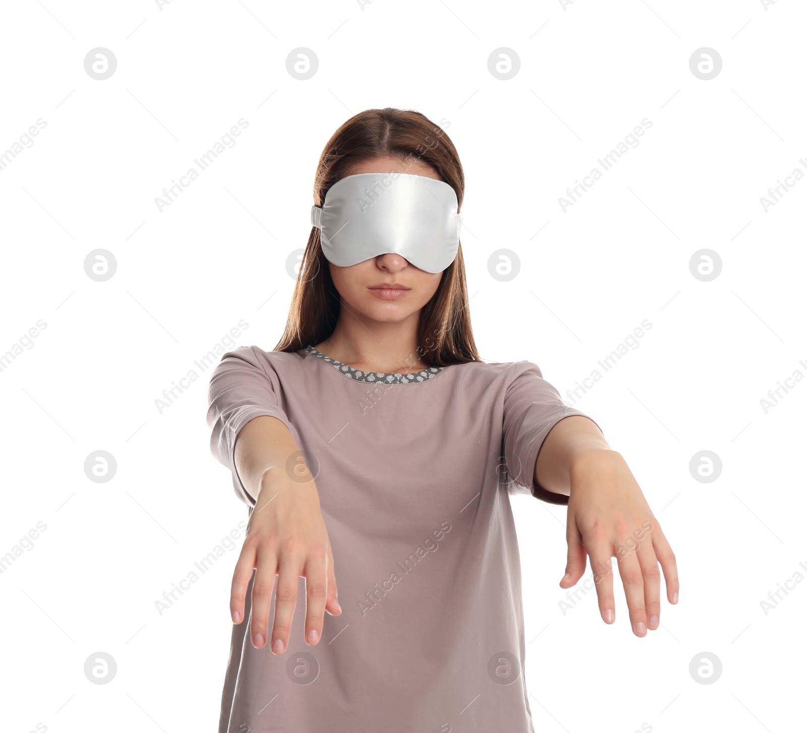 Photo of Young woman wearing pajamas and mask in sleepwalking state on white background