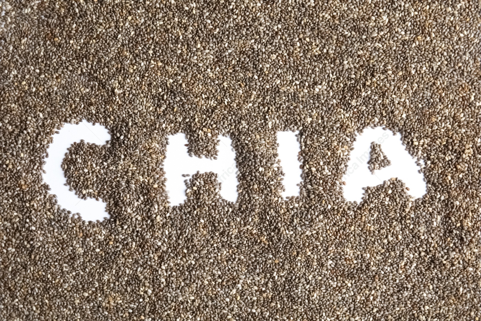 Photo of Word CHIA written in seeds on white background, top view