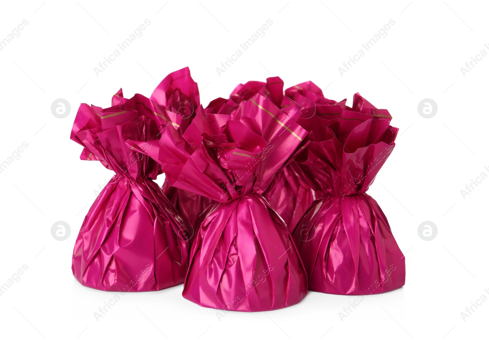 Photo of Delicious candies in pink wrappers on white background