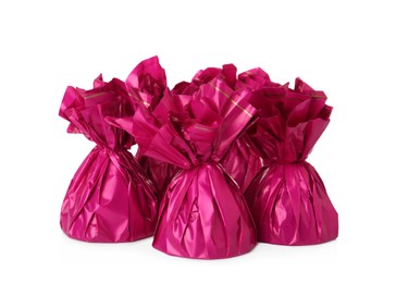 Delicious candies in pink wrappers on white background