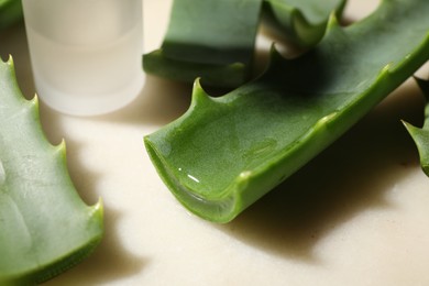 Photo of Slices of fresh aloe vera leaves with gel on light table, closeup