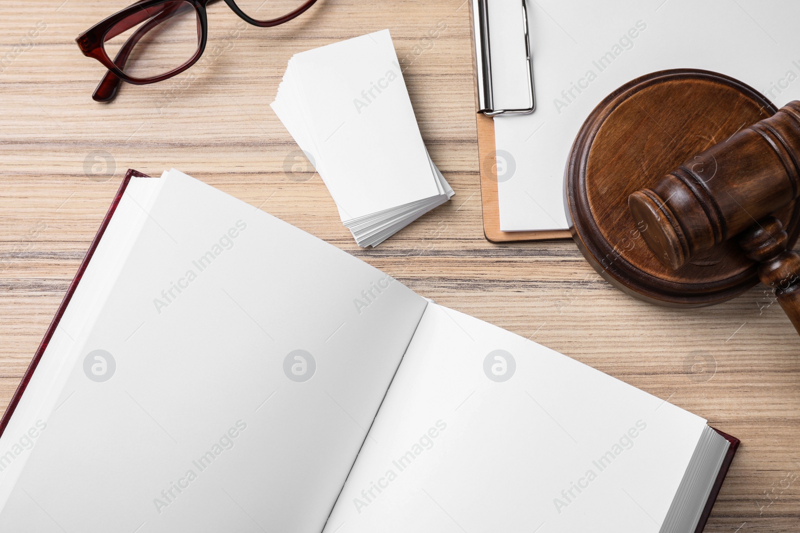 Photo of Flat lay composition with domestic violence law book and business cards on wooden table