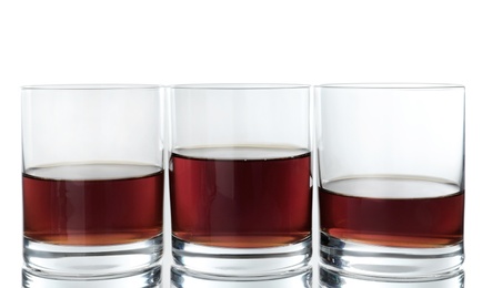 Glasses of scotch whiskey on white background
