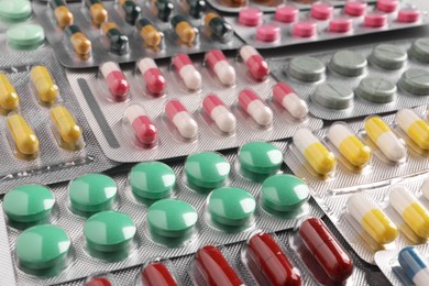 Photo of Many blisters with different pills as background, closeup