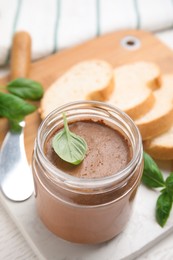 Delicious meat pate, fresh bread and basil on white wooden table