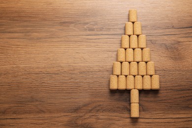 Photo of Christmas tree made of wine corks on wooden table, top view. Space for text