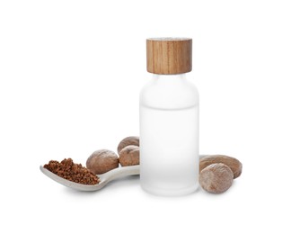 Bottle of nutmeg oil, nuts and powder on white background