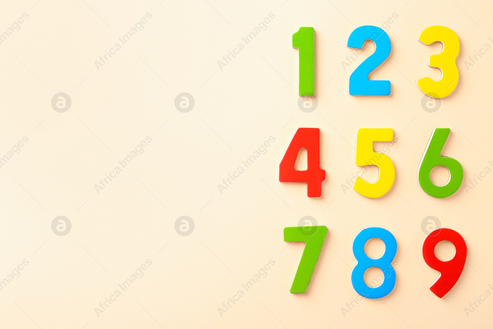 Photo of Colorful numbers on beige background, flat lay. Space for text