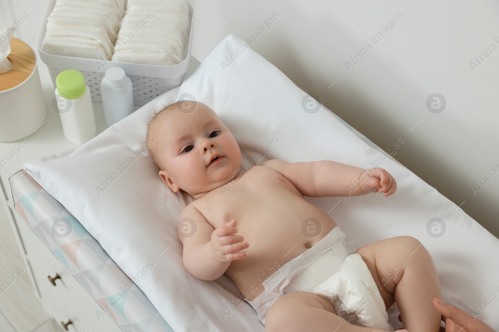 Photo of Mother with her baby at changing table indoors, closeup