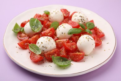 Photo of Tasty salad Caprese with tomatoes, mozzarella balls and basil on pink background, closeup