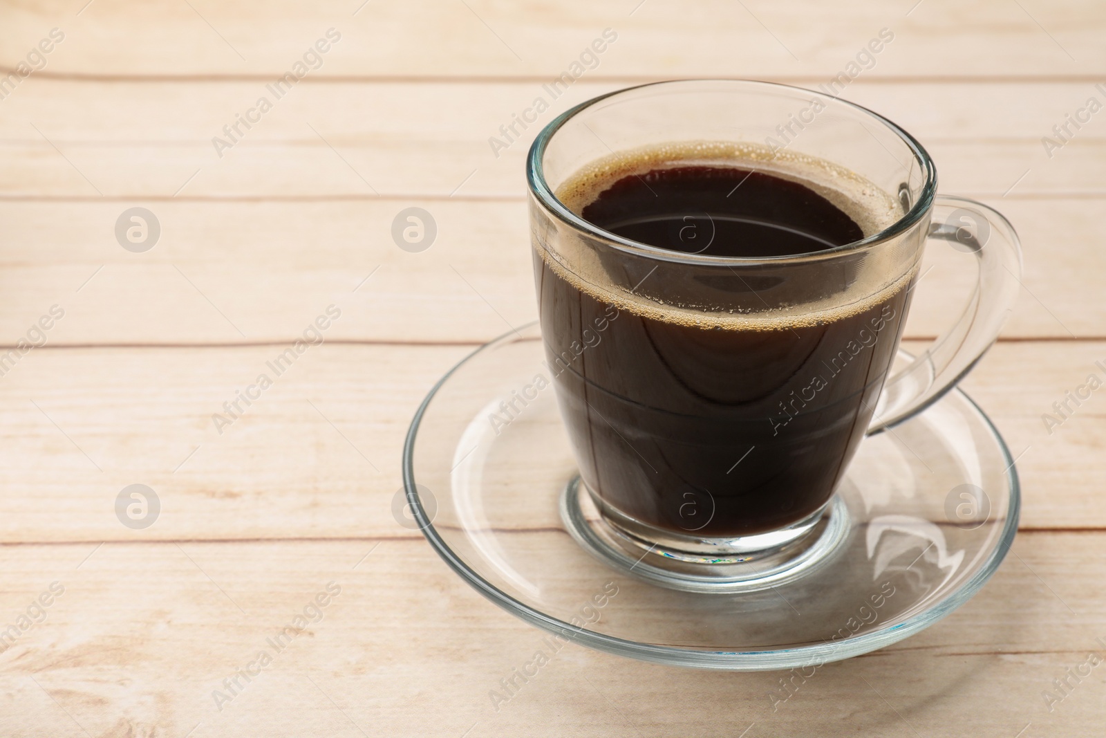 Photo of Cup of aromatic coffee on light wooden table, closeup. Space for text