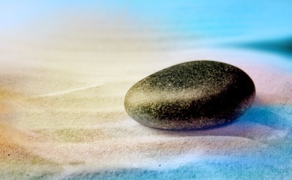 Zen garden stone on sand with pattern, space for text. Meditation and harmony