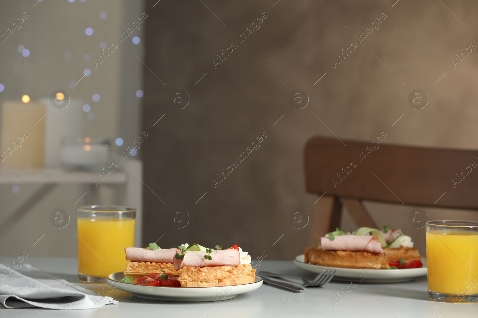 Photo of Delicious Belgian waffles with ham and vegetables served light grey table indoors, space for text
