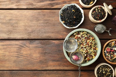 Photo of Many different herbal teas on wooden table, flat lay. Space for text
