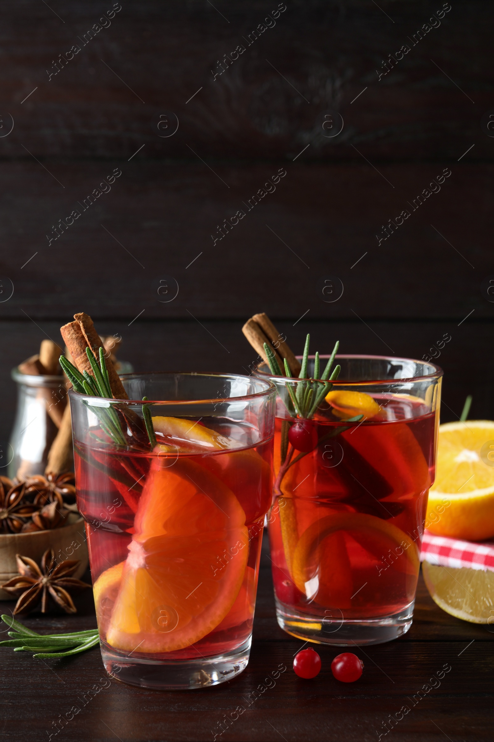 Photo of Aromatic punch drink and ingredients on wooden table