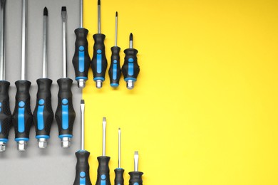 Photo of Set of screwdrivers on color background, flat lay. Space for text