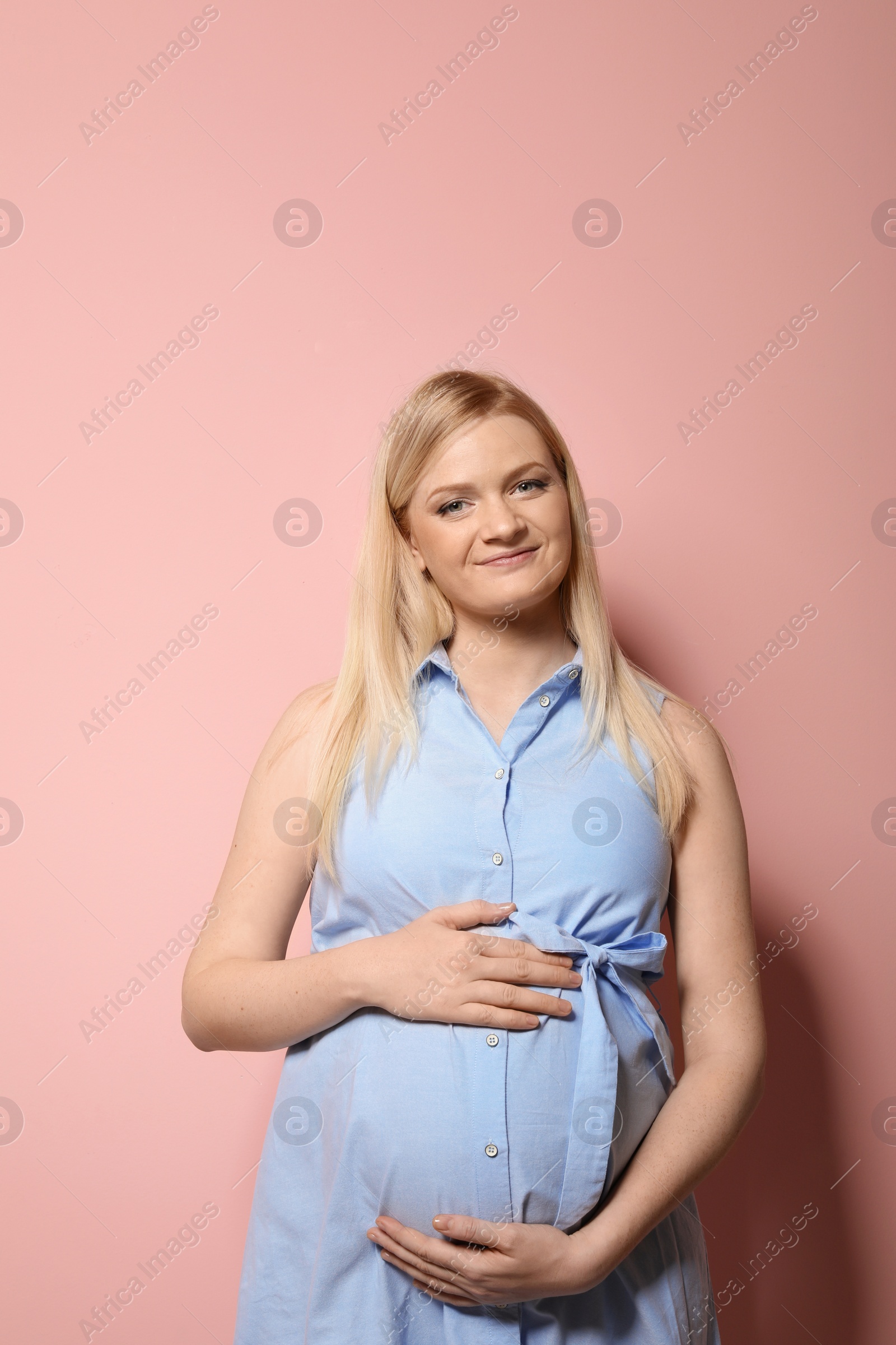 Photo of Beautiful pregnant woman in dress on color background