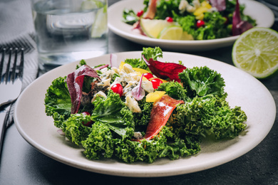 Tasty fresh kale salad on grey table, closeup. Food photography  