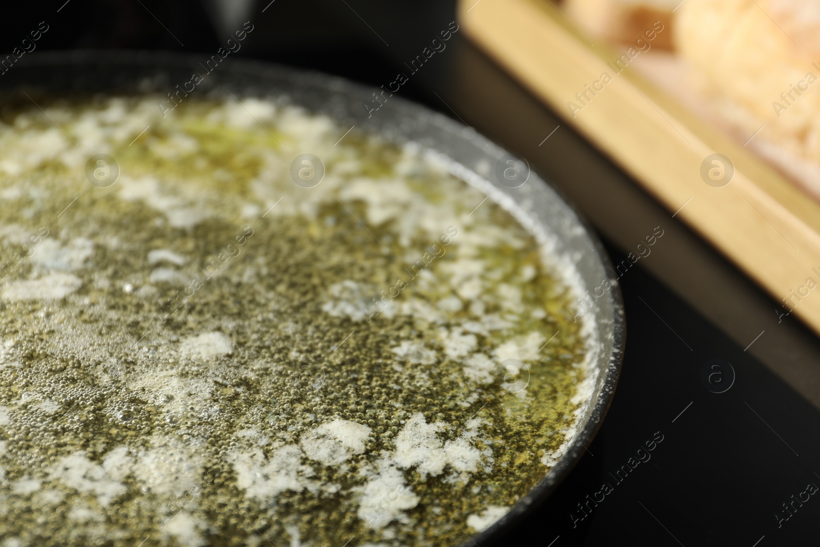 Photo of Melted butter in frying pan on table, closeup