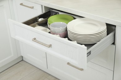 Clean plates and bowls in drawer indoors