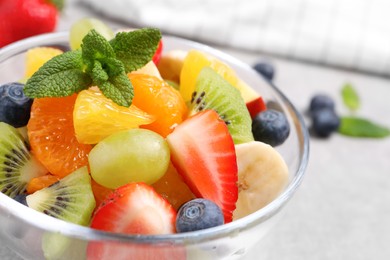 Photo of Delicious fresh fruit salad in bowl on table, closeup
