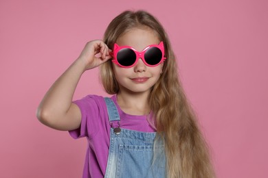 Girl in stylish sunglasses on pink background