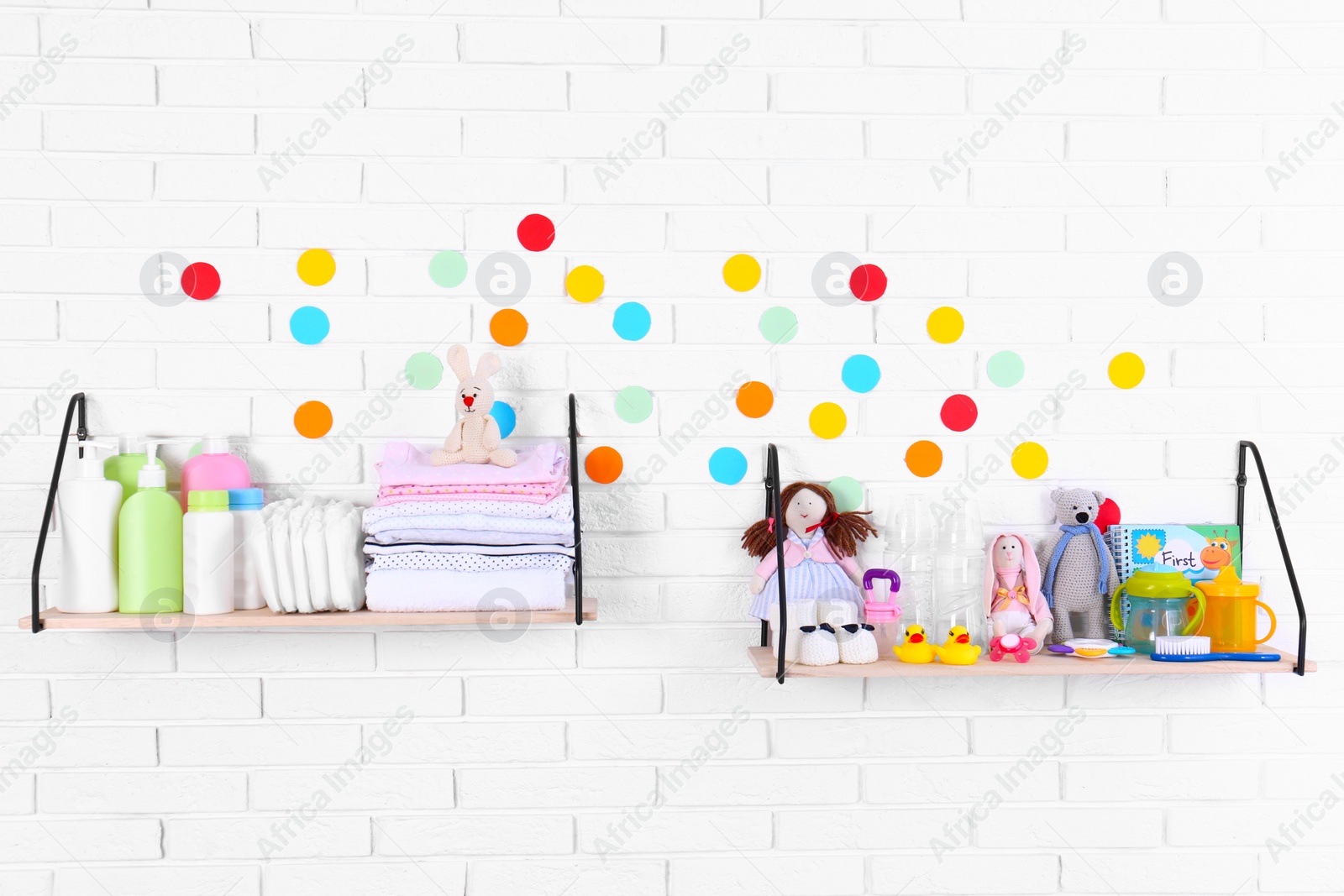 Photo of Baby accessories on shelves near white brick wall