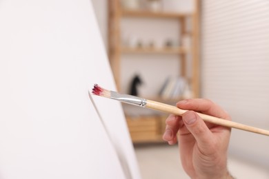 Photo of Man painting on canvas in studio, closeup