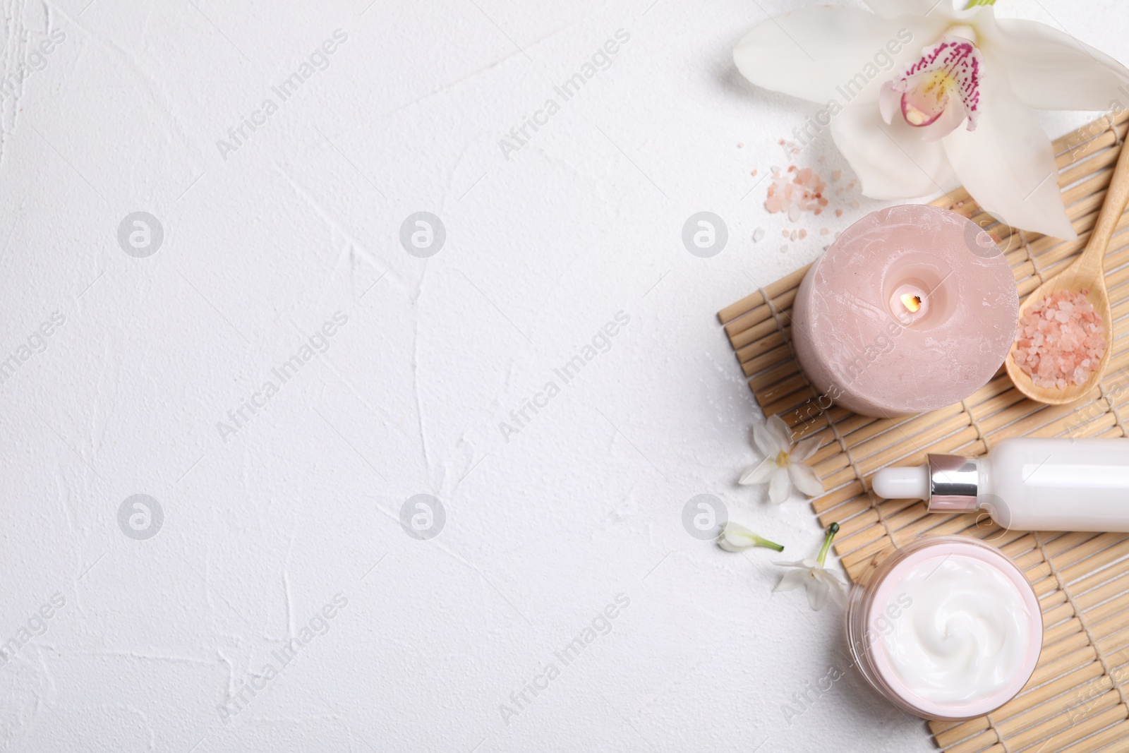 Photo of Beautiful spa composition with cosmetic products and flowers on white table, flat lay. Space for text