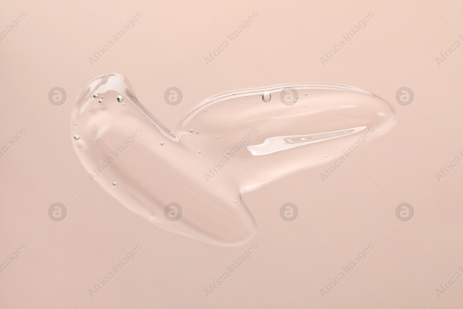 Photo of Sample of cleansing gel on pastel pink background, top view. Cosmetic product