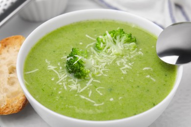 Photo of Delicious broccoli cream soup with cheese on white table, closeup
