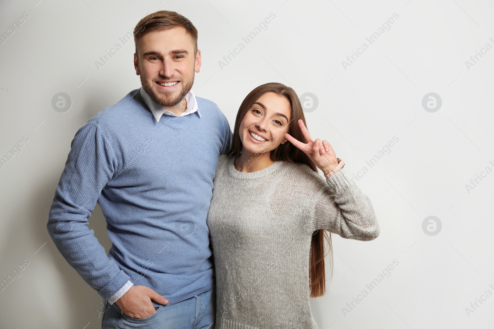 Photo of Young couple in warm sweaters on white background