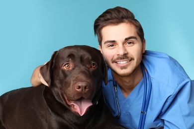 Photo of Veterinarian doc with dog on color background